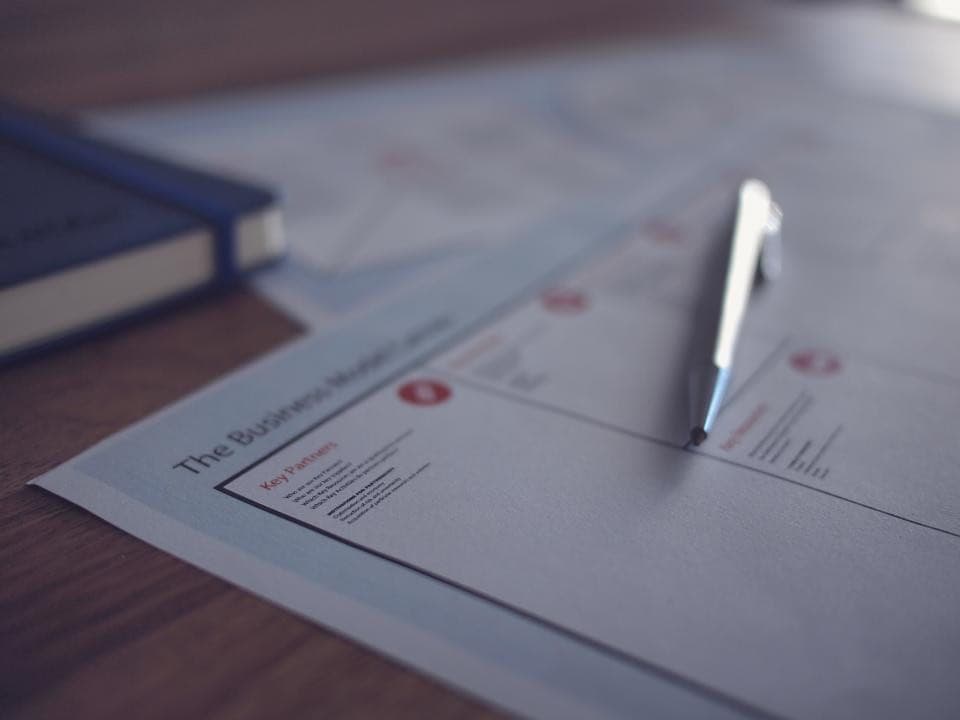 A business planning document on a desk with a pen resting on it