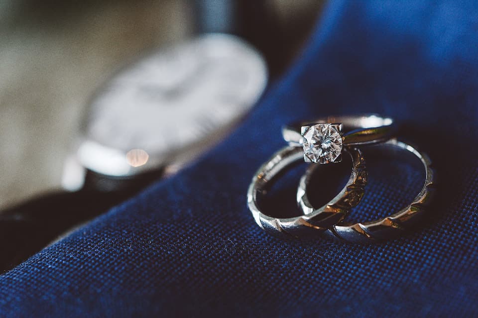A close-up of wedding rings set down on a jacket