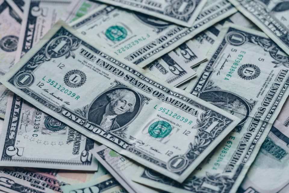 A close-up of US one and five dollar bills fanned out