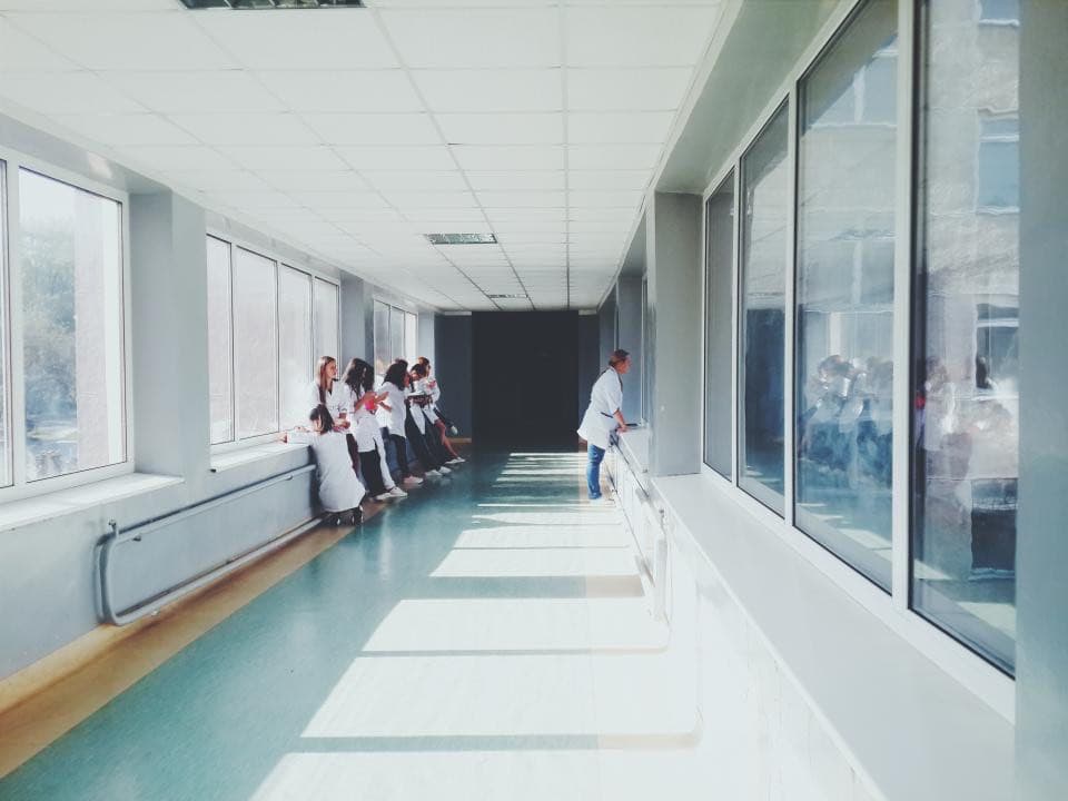 A bright, empty hospital corridor with large windows
